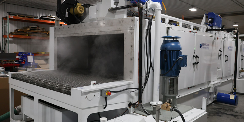 Industrial parts washer with conveyor belt and steam